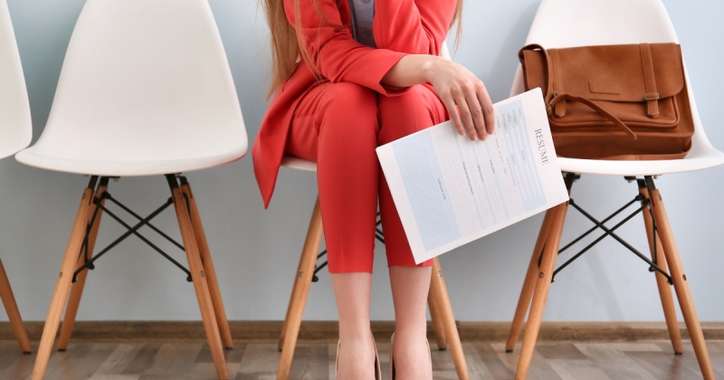 Woman in professional attire with her resume in hand.