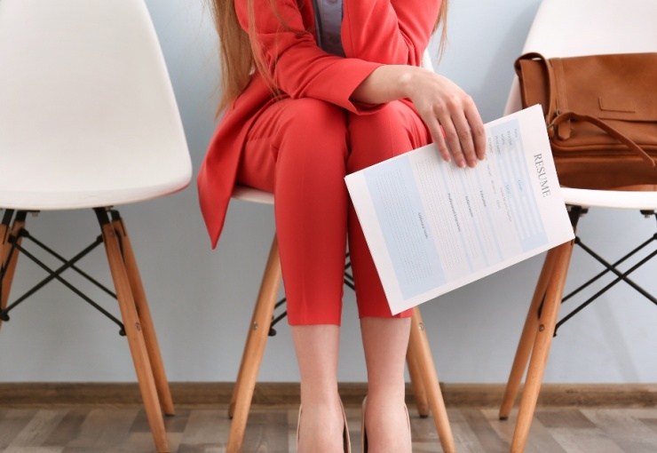 Woman in professional attire with her resume in hand.